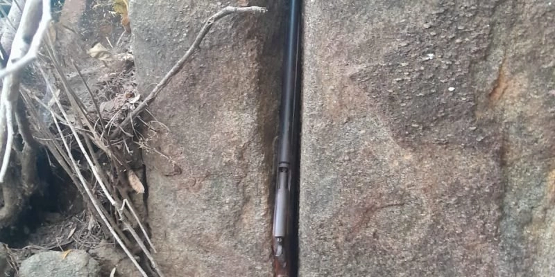 Polícia encontra arma entre rochas em área de mata 