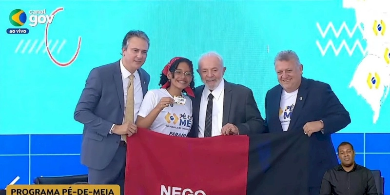 Aluna da rede estadual recebe cartão do Pé-de-Meia do presidente Lula durante cerimônia no Palácio do Planalto