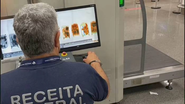 Agente da Receita Federal analisa raio-x de malas com 57 kg de cocaína no Aeroporto de Brasília