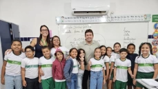Helder ao lado de Bruna e alunos