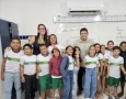 Helder ao lado de Bruna e alunos